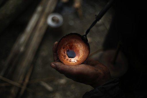 A Naga man cooks raw opium as he prepares it for smoking at hunter's base in an opium field during a hunting trip between Donhe and Lahe township in the Naga Self-Administered Zone