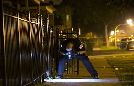 A Chicago police officer documents the crime scene where 7-year-old Amari Brown was shot and killed in Chicago