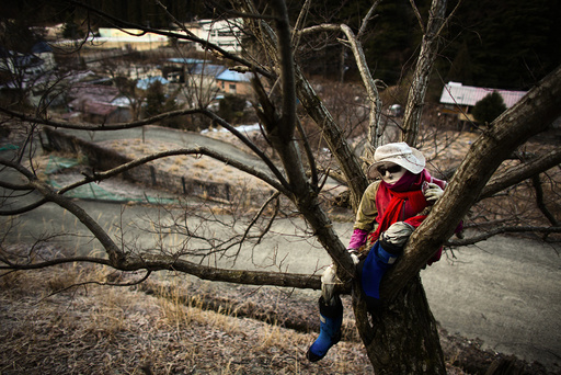 A scarecrow sits on a tree in the mountain village of Nagoro