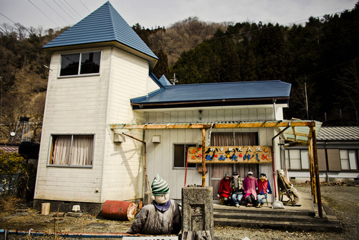 Scarecrows sit in front of a house in the mountain village of Nagoro