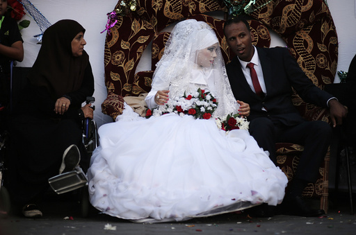 A Palestinian couple speaks with each other during their wedding ceremony at a United Nations-run school sheltering displaced Palestinians from the Israeli offensive, in Shati refugee camp in Gaza City