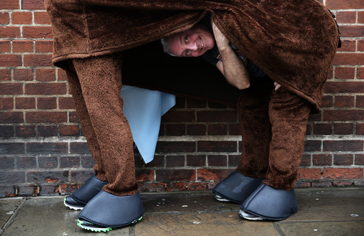 A participant peeks from his costume before the start of the the annual London Pantomime Horse Race in Greenwich, Britain
