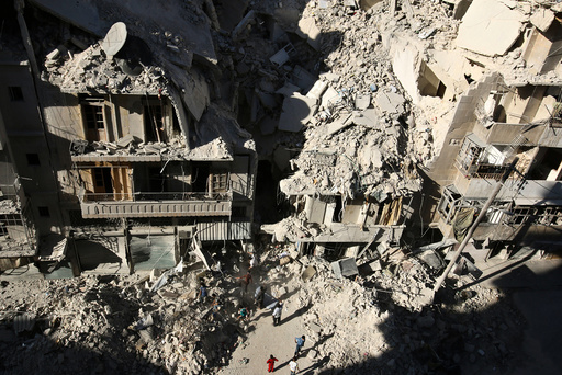 People dig in the rubble in an ongoing search for survivors at a site hit previously by an airstrike in the rebel-held Tariq al-Bab neighborhood of Aleppo