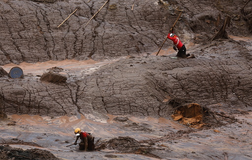 Rescue workers search for victims at the Bento Rodrigues district that was covered with mud after a dam, owned by Vale SA and BHP Billiton Ltd, burst in Mariana