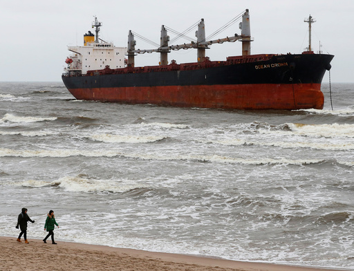 People walk past stranded cargo ship Ocean Crown in Klaipeda