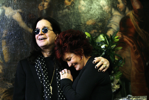 Ozzy and Sharon Osbourne smile pose in front of their belongings in Beverly Hills