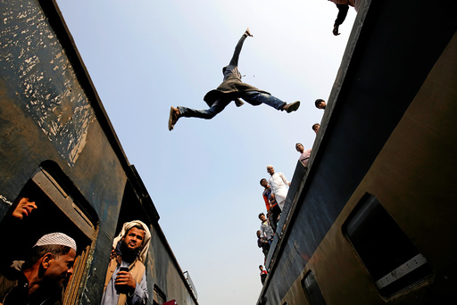 A commuter jumps between trains upon arrival at a station on the outskirts of Dhaka