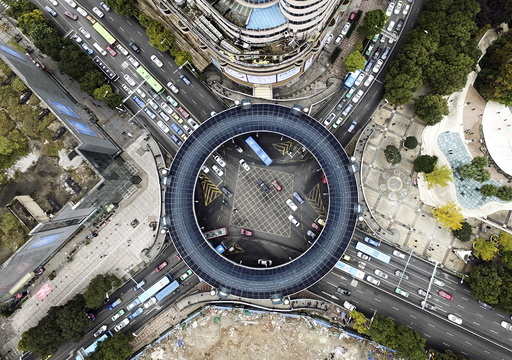 An aerial view shows cars passing below a pedestrian overpass in the shape of a circle in Guiyang