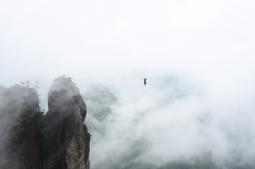 A competitor walks on tightrope during a performance in Taizhou