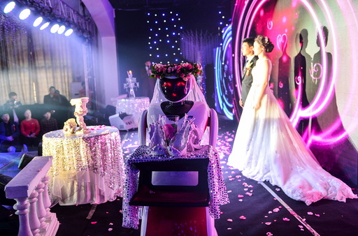 A robot dressed up as a bridesmaid carries glasses as it serves a wedding in Tianjin