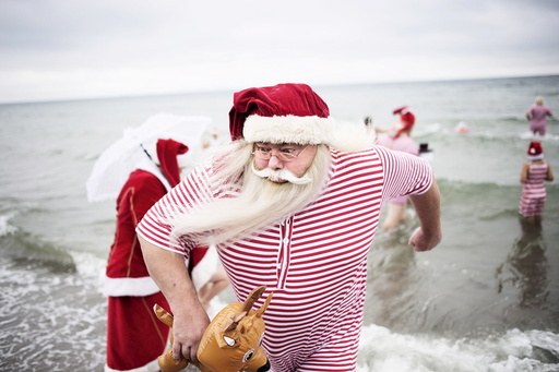 Participants of the World Congress of Santa Clauses 2015 take part in the annual swim at Bellevue beach, north of Copenhagen
