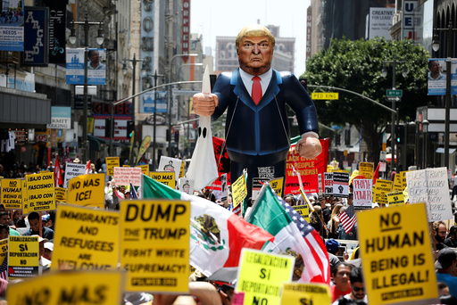 People march with an inflatable effigy of Republican presidential candidate Donald Trump during an immigrant rights May Day rally in Los Angeles