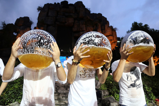 People drink beer from fish bowls at a beer drinking competition in Hangzhou