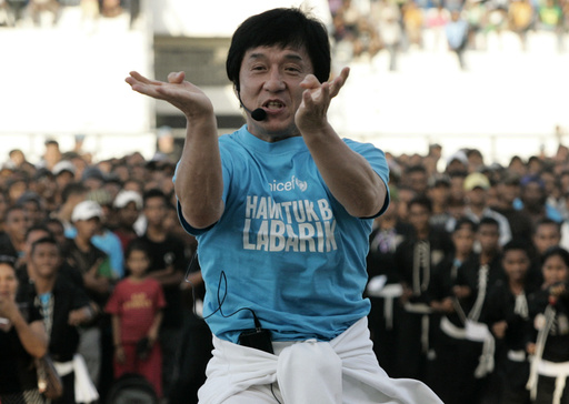 Action film star and UNICEF Goodwill Ambassador Chan demonstrates martial arts move in front of East Timorese youths in Dili