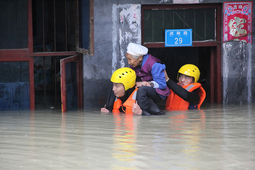 Rescuers save a resident from a flooded building in Chongqing