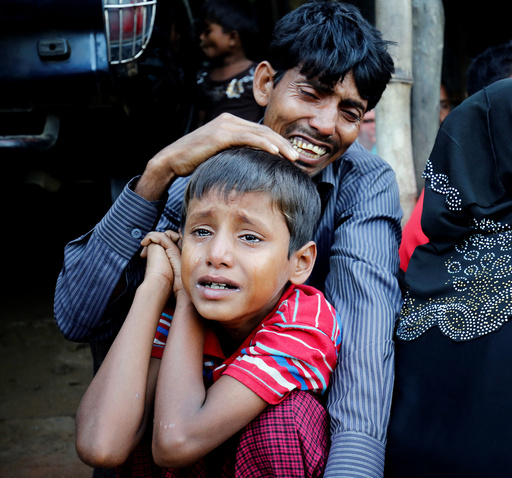 A Rohingya Muslim man and his son cry after being caught by Border Guard Bangladesh while illegally crossing at a border check point in Coxs Bazar