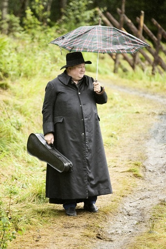 Knut Buen med sort skinnfrakk og paraply under øving til Marispelet. Teater, Sogelandet, Marispelet, Rjukan