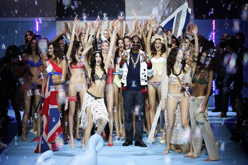 US rapper Snoop Lion, known as Snoop Dogg performs next to models during the Etam Live Show Lingerie at Piscine Molitor during Paris Fashion Week