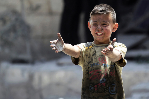 A boy, whose brother was killed, reacts at site hit by airstrikes in rebel-controlled area of Maaret al-Numan town in Idlib province