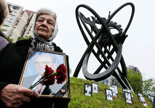 A woman holds a portrait of her relative, a victim of the Chernobyl nuclear disaster, during a ceremony in Kiev