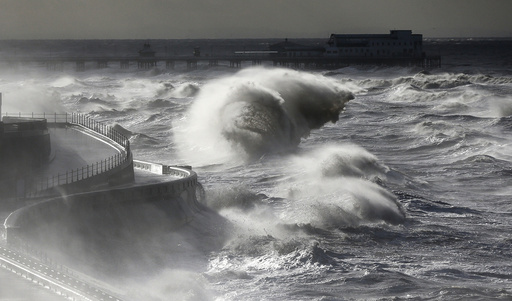 Waves break in front of the South Pier on Blackpool Promenade, northern Britain
