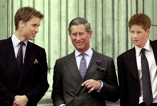 PRINCE CHARLES SMILES AS HE STANDS WITH HIS TWO SONS AT BUCKINGHAM PALACE