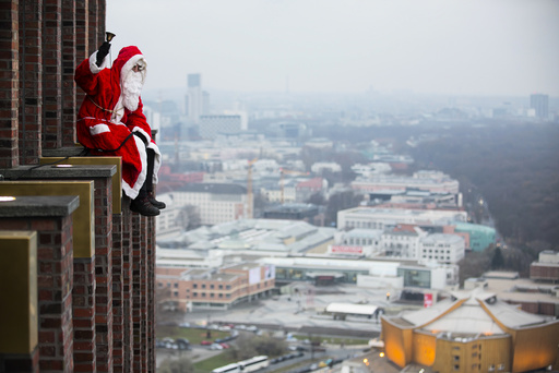 A man dressed as a Santa Claus poses at the front of the Kollhoff Tower at Potsdamer Platz square in Berlin