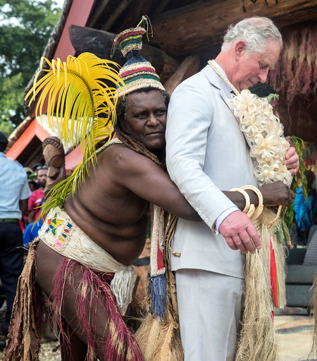 Britain's Prince Charles is given a grass skirt to wear prior to receiving a chiefly title during a visit to the Chiefs' nakamal, as he visits the South Pacific island of Vanuatu