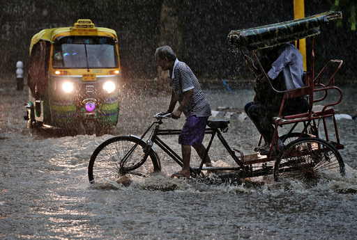 A man pedals his cycle rickshaw during monsoon rains in New Delhi