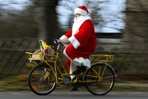 A man dressed as Father Christmas rides a bicycle in the village of Himmelpfort