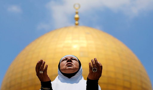 A Palestinian woman prays on the first Friday of the holy fasting month of Ramadan, on the compound known to Muslims as Noble Sanctuary and to Jews as Temple Mount, in Jerusalem's Old City
