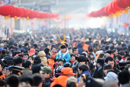 A girl wears a monkey king headwear at a festival fair during Chinese Lunar New Year celebrations in Qingdao