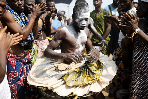 A devotee is cheered as he dances at the annual voodoo festival in Ouidah
