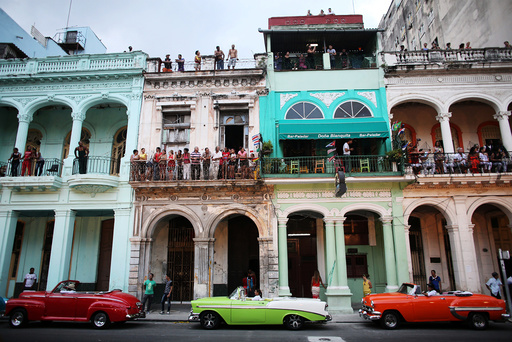 People stand on balconies prior to a fashion show displaying creations by German designer Karl Lagerfeld as part of his latest inter-seasonal Cruise collection for fashion house Chanel at the Paseo del Prado street in Havana, Cuba