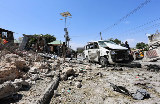 Somali policemen attend scene of a suicide attack outside the main base of an African Union peacekeeping force in Mogadishu