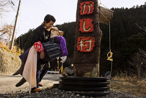 Tsukimi Ayano carries a scarecrow to place it on the road leading into the mountain village of Nagoro