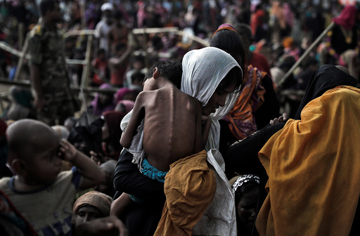 A woman carries her ill child in a refugee camp at Cox's Bazar