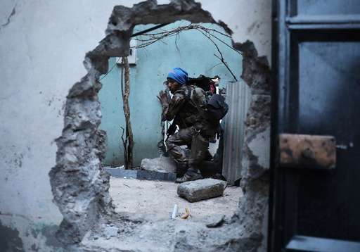An Iraqi Special Forces soldier moves through a hole as he searches for Islamic State fighters in Mosul