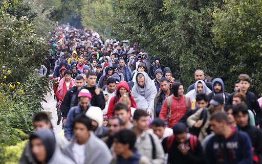 Migrants walk to the Austrian border in Nickelsdorf from Hegyeshalom