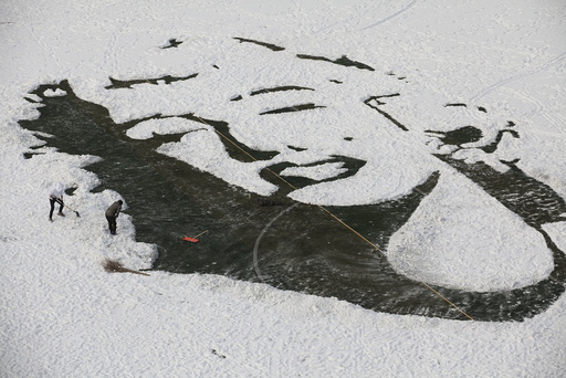 University students create an image of Marilyn Monroe by clearing snow on a soccer pitch, in Changchun