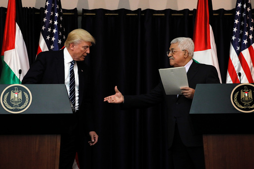 Abbas extends his hand to Trump during their remarks after their meeting at the Presidential Palace in the West Bank city of Bethlehem