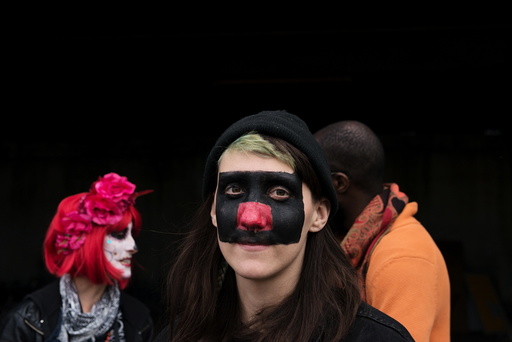 A woman with face paint poses for a photograph during 