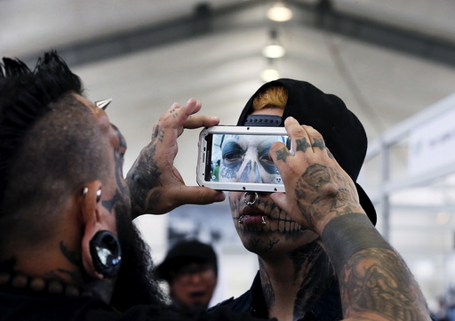 Venezuelan tattoo artist and body modifier Emilio Gonzalez takes a picture of the eyeball tattoo on Eduardo Henriquez of Chile during the latin america convention of tattoo and suspension in Valparaiso city