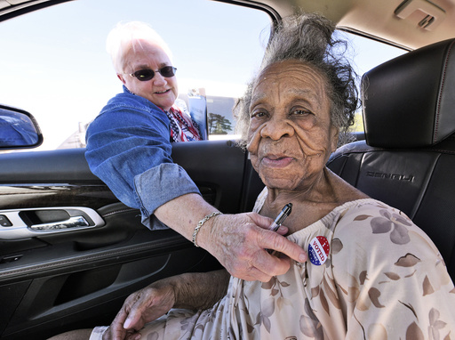 100 year old Grace Bell Hardison receives an I Voted Today sticker from election official Elain