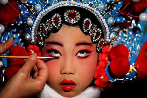 A participant has her make-up done during a traditional Chinese opera competition at the National Academy of Chinese Theatre Arts in Beijing