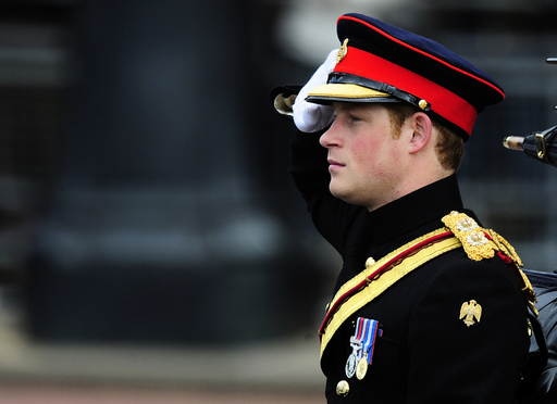 Britain's Prince Harry salutes as he leaves Buckingham Palace to attend the Trooping the Colour ceremony in London