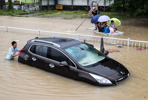 A trapped car is pushed along a flooded street after typhoon Soudelor hit Fuzhou