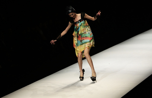 A model nearly falls as she presents a creation at China Fashion Week in Beijing