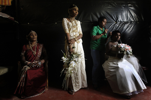 Former LTTE female rebel fighters and brides look on as an ethnic Tamil gets ready before the start of a mass wedding in Kilinochchi