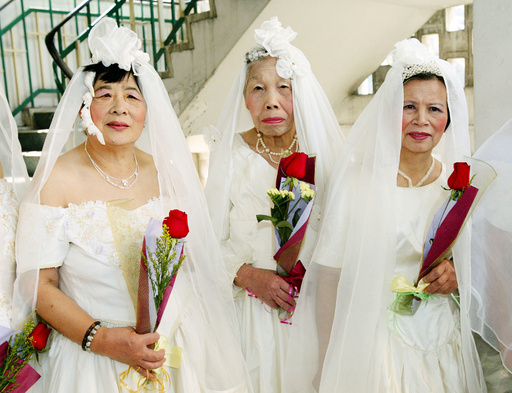 ELDERLY WOMEN RECEIVE FLOWERS AT A VALENTINE'S DAY CEREMONY IN HONG KONG